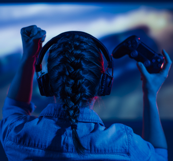 img d'une joueuse mains levées avec une manette de jeuxvidéo